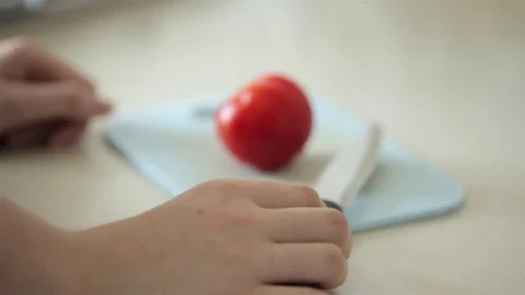 Close up on cutting tomato in the kitchen Stock Footage 83356498