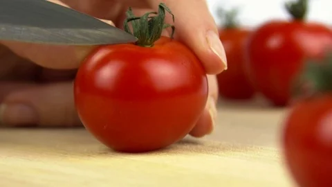 A close-up of cutting a tomato with a knife. Video stock 83055034