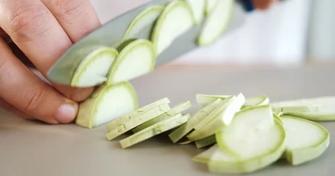 Close up of cutting zucchini with knife. Chef cooking vegetables in restaurant. Stock Footage 133368033
