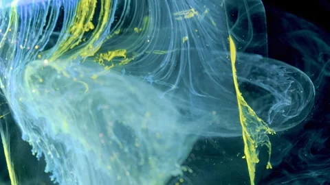 Close-up cyan and yellow inks streaming through dark liquid with translucent rib Stock Footage 340784687