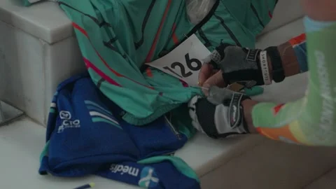 Close-Up of Cyclist Fixing Race Bib on Jersey Before Event Stock Footage 333698849