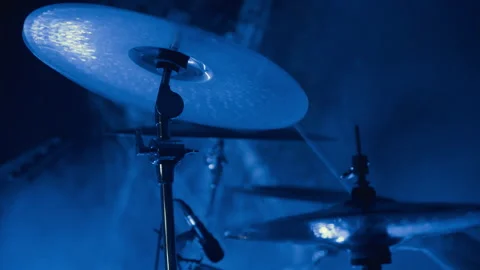 Close up of a cymbal on a drum set at a live rock concert under blue stage Stock Footage 341645277