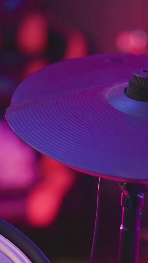 Close up cymbal struck under vibrant purple and pink stage lighting with motion Stock Footage 346795769