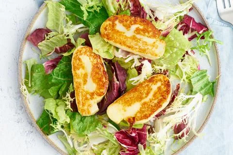 Close up cyprus fried halloumi with healthy salad mix. Lchf, pegan, fodmap Stock Photos