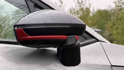 Close-up of a damaged car side view mirror secured with black tape, covered in Stock Photos