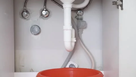 Close Up of Damaged Drain Pipe Dripping Water from Sink in Modern Kitchen Stock Footage 313546244