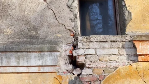 Close-up of a damaged old building wall with exposed bricks, cracked plaster Stock Footage 336088595