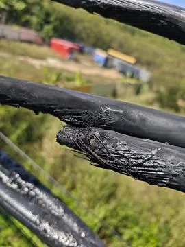 Close up of damaged twisted aerial bundle cable with melted insulation. Stock Photos