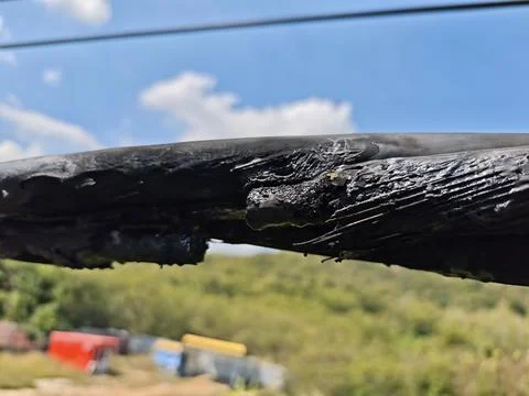 Close up of damaged twisted aerial bundle cable with melted insulation. Stock Photos