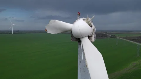 Close-up of a damaged wind turbine blade on a large green field with multiple Stock Footage 307592965