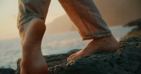 Close-up of dancer bare feet stepping on volcanic rocks at sunset Stock Footage 317721730