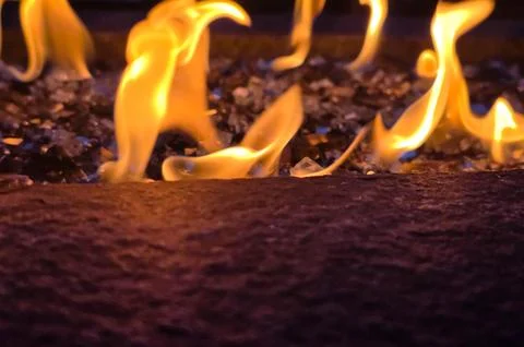 Close-Up of Dancing Flames Over Fire Glass in Outdoor Gas Fire Pit Stock Photos