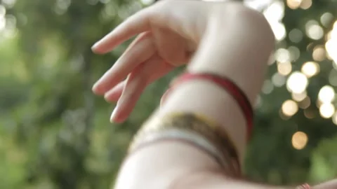 Close-up of dancing hands in colorful bracelets in a park. Stock Footage 146713215