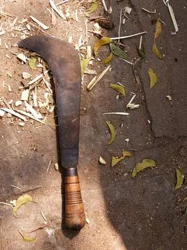 Close up of dangerous-looking, rusty old machete on ground, copy space Stock Photos