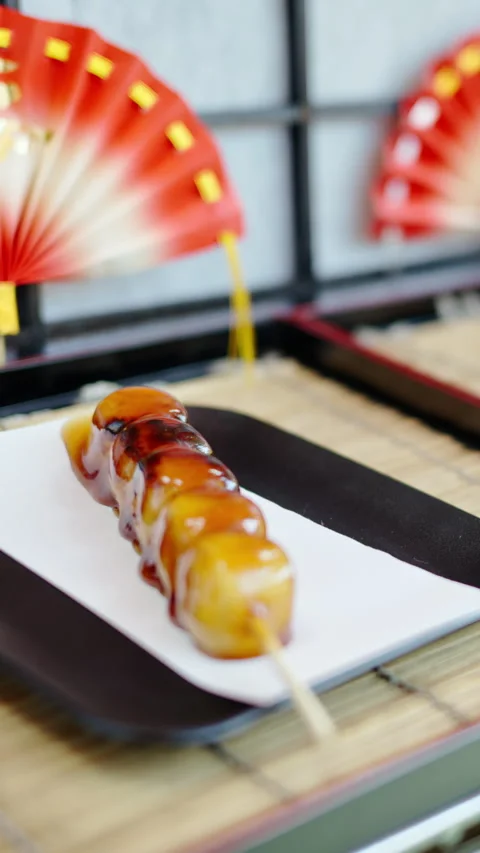 Close up of dango served on a skewer at a street food market in Japan. Vertical Stock Footage 309660555