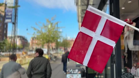Close up of Danish flag waving outside shop on Copenhagen city street, Denmark Stock Footage 339286000
