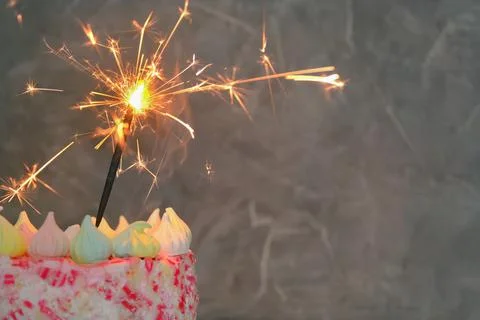 Close-up on a dark background a cake with a lit sparkler. Concept - holiday Stock Photos