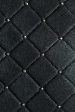 Close up. Dark black leather texture background with shiny pin. Stock Photos