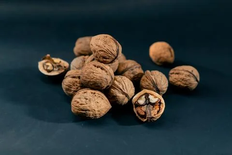 Close-up on dark blue background with side lighting lie whole and split walnuts Foto stock