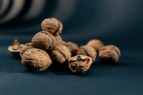 Close-up on dark blue background with side lighting lie whole and split walnuts 写真素材