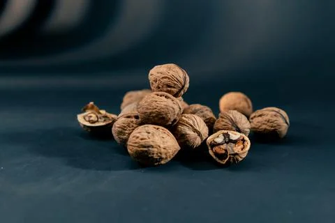 Close-up on dark blue background with side lighting lie whole and split walnuts Stockfoto's