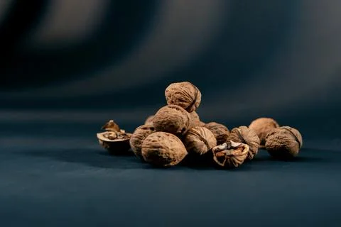 Close-up on dark blue background with side lighting lie whole and split walnuts Foto stock