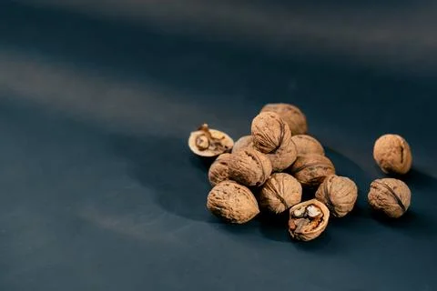 Close-up on dark blue background with side lighting lie whole and split walnuts 写真素材