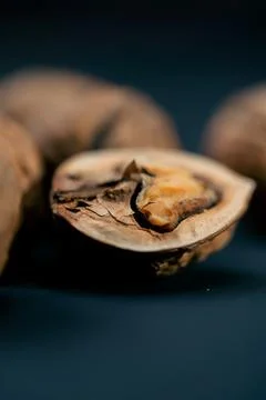 Close-up on dark blue background with side lighting lie whole and split walnuts 写真素材