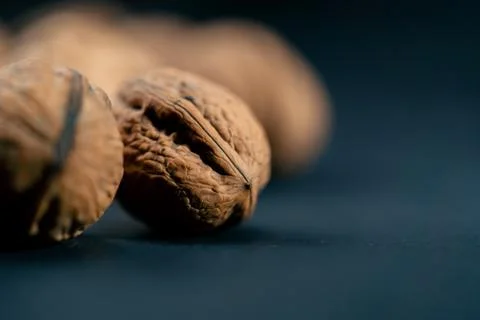 Close-up on dark blue background with side lighting lie whole and split walnuts 写真素材