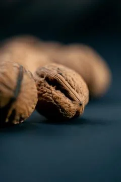 Close-up on dark blue background with side lighting lie whole and split walnuts Stock Photos