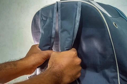 Close up of a dark blue backpack with white trim and gray straps, being hel.. 스톡 사진