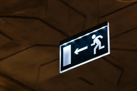 Close up dark blue emergency exit sign in corridor. Stock Photos