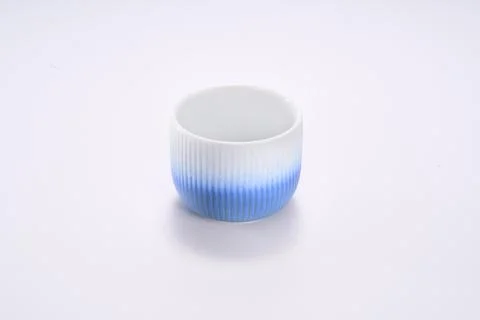 Close-up of dark blue striped ceramic tea cup on white background Stock Photos