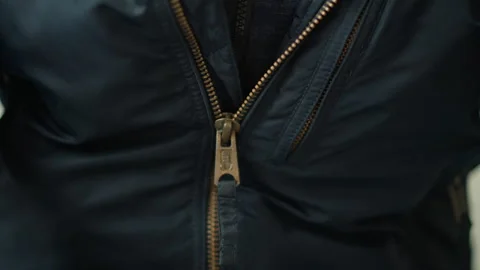 Close up of dark blue zippered outerwear with brass colored hardware showing Stock Footage 346658655