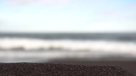 Close-up of dark colored sea sand or small pebbles. Footage. Blurred background Stock Footage 257947626