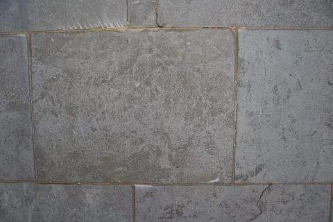 Close-up of a dark gray rectangular tile floor with wear due to time and use Stock Photos