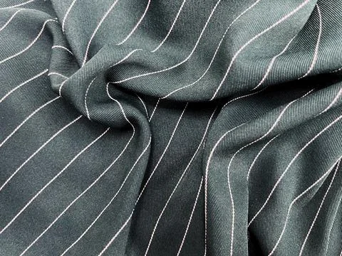 Close-up of dark green fabric with diagonal white stripes. Stock Photos