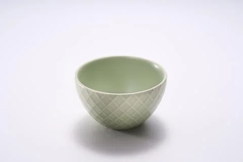 Close-up of dark green grid striped ceramic rice bowl on white background Stockfoto's