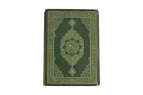 A close-up of a dark green hardcover holy book adorned with intricate gold patte Stock Photos