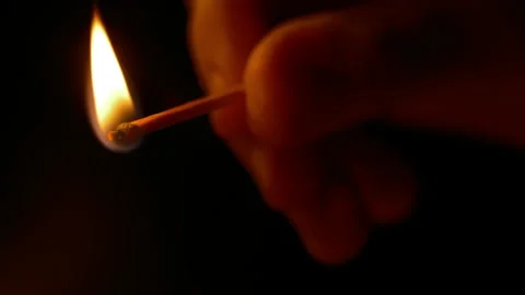 Close up, In the dark a hand lights a match Stock Footage 257662344