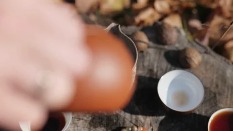 Close-up. dark pu-erh tea is poured from a teapot into a clay pot. traditio.. Stock Footage 229859281