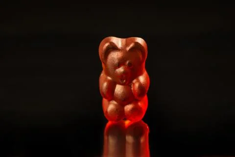 Close-up of a dark red gummy bear candy on a black background Stockfoto's