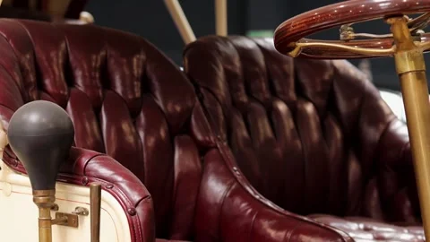 Close-up of dark red tufted leather seats and wooden steering wheel inside Video stock 306155078