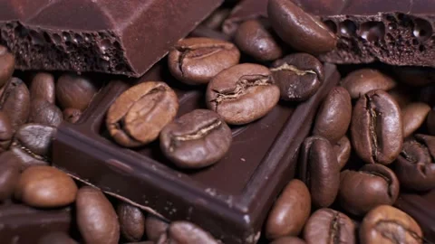 Close-up of dark roasted coffee beans and chocolate on rotating table. Stock Footage 140108629