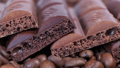Close-up of dark roasted coffee beans and chocolate on rotating table. Stock Footage 140208649