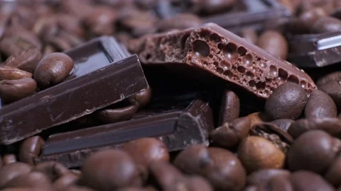 Close-up of dark roasted coffee beans and chocolate on rotating table. Stock Footage 140209475
