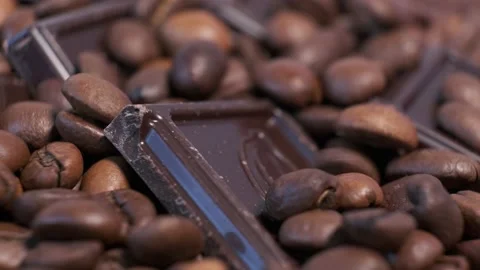 Close-up of dark roasted coffee beans and chocolate on rotating table. Stock Footage 140353332