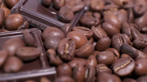 Close-up of dark roasted coffee beans and chocolate on rotating table. Stock Footage 140353342