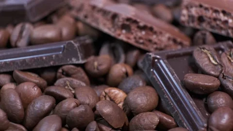 Close-up of dark roasted coffee beans and chocolate on rotating table. Stock Footage 140464745