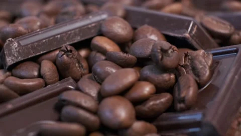 Close-up of dark roasted coffee beans and chocolate on rotating table. Stock Footage 140465148